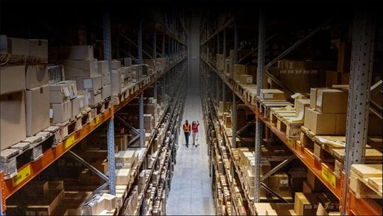 Two people walking in a warehouse